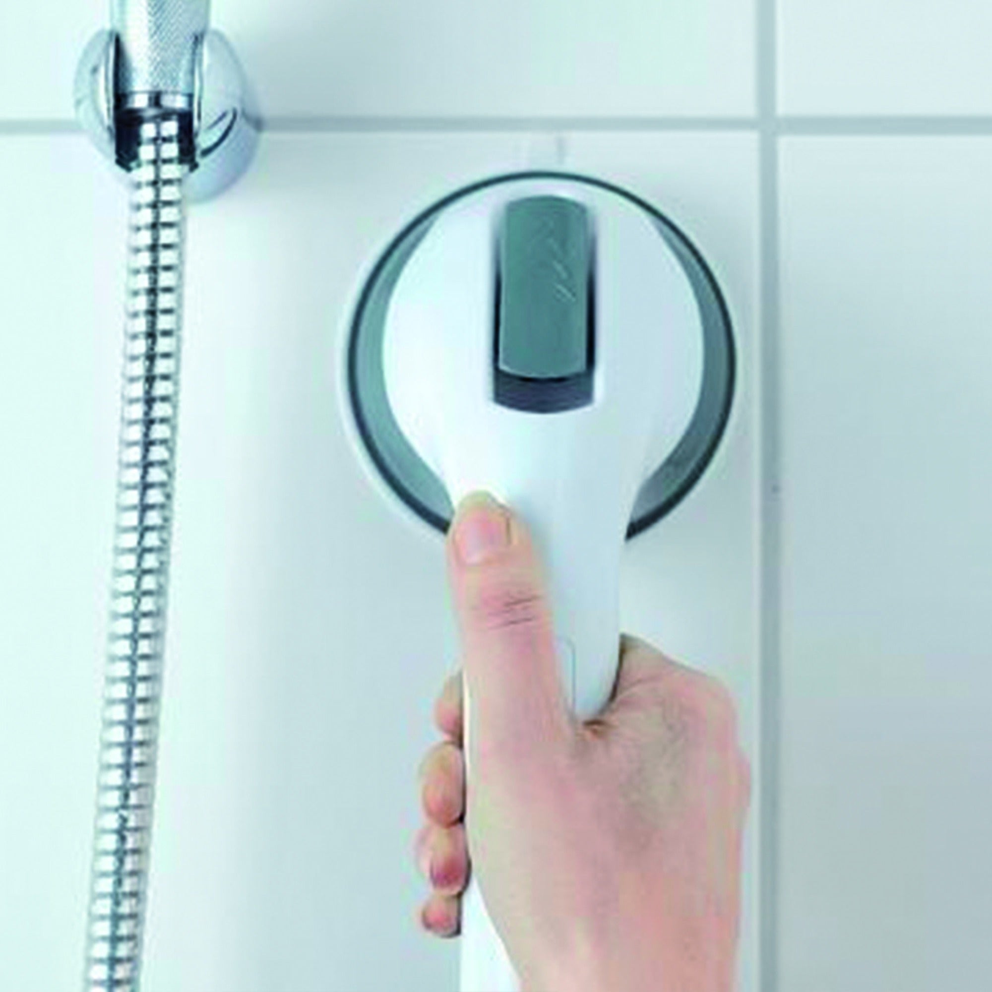 Asidero de baño con ventosas instalado en pared de ducha junto al grifo