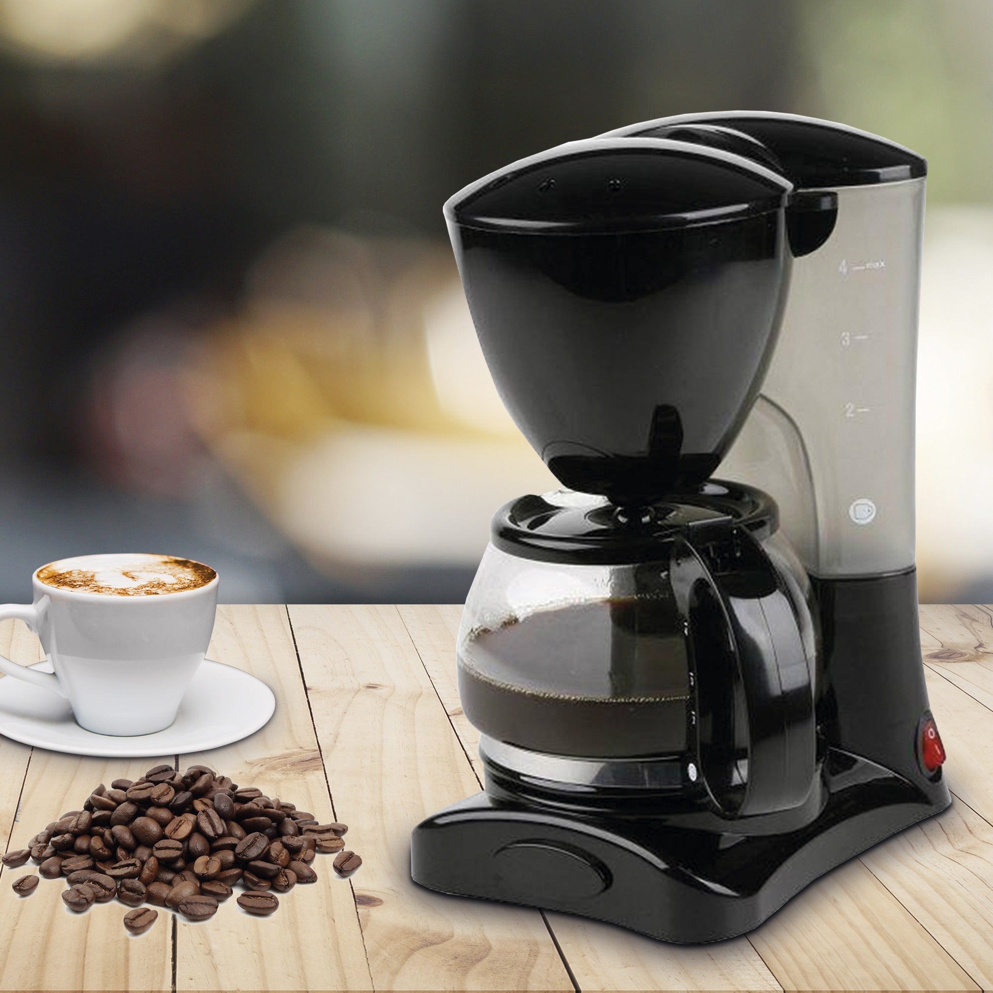 Cafetera eléctrica de goteo negra de 0,6L junto a granos de café y taza