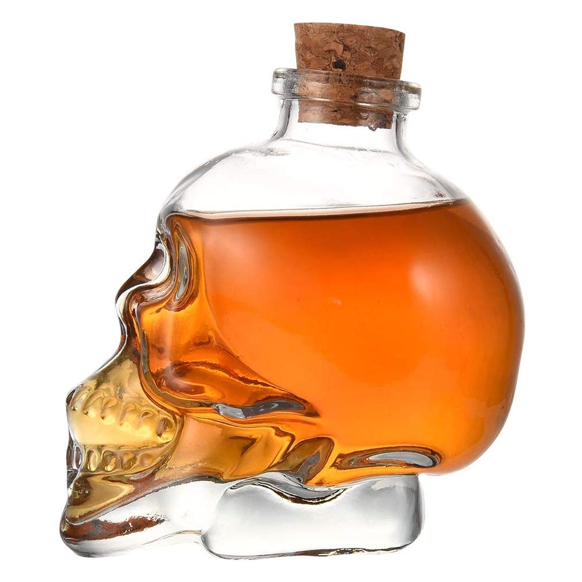 Licorera calavera de cristal sola con licor ambar sobre fondo blanco