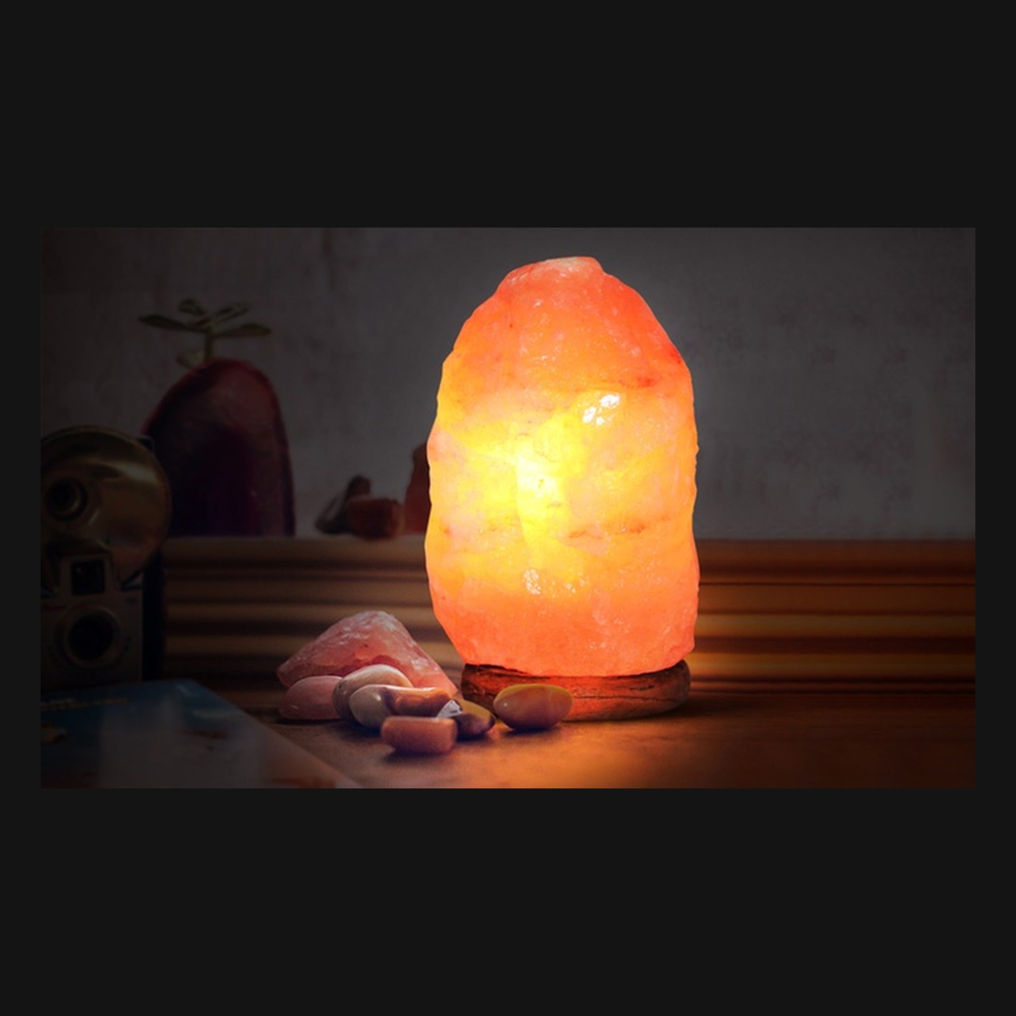 Mini lámpara de sal del Himalaya encendida junto a piedras decorativas
