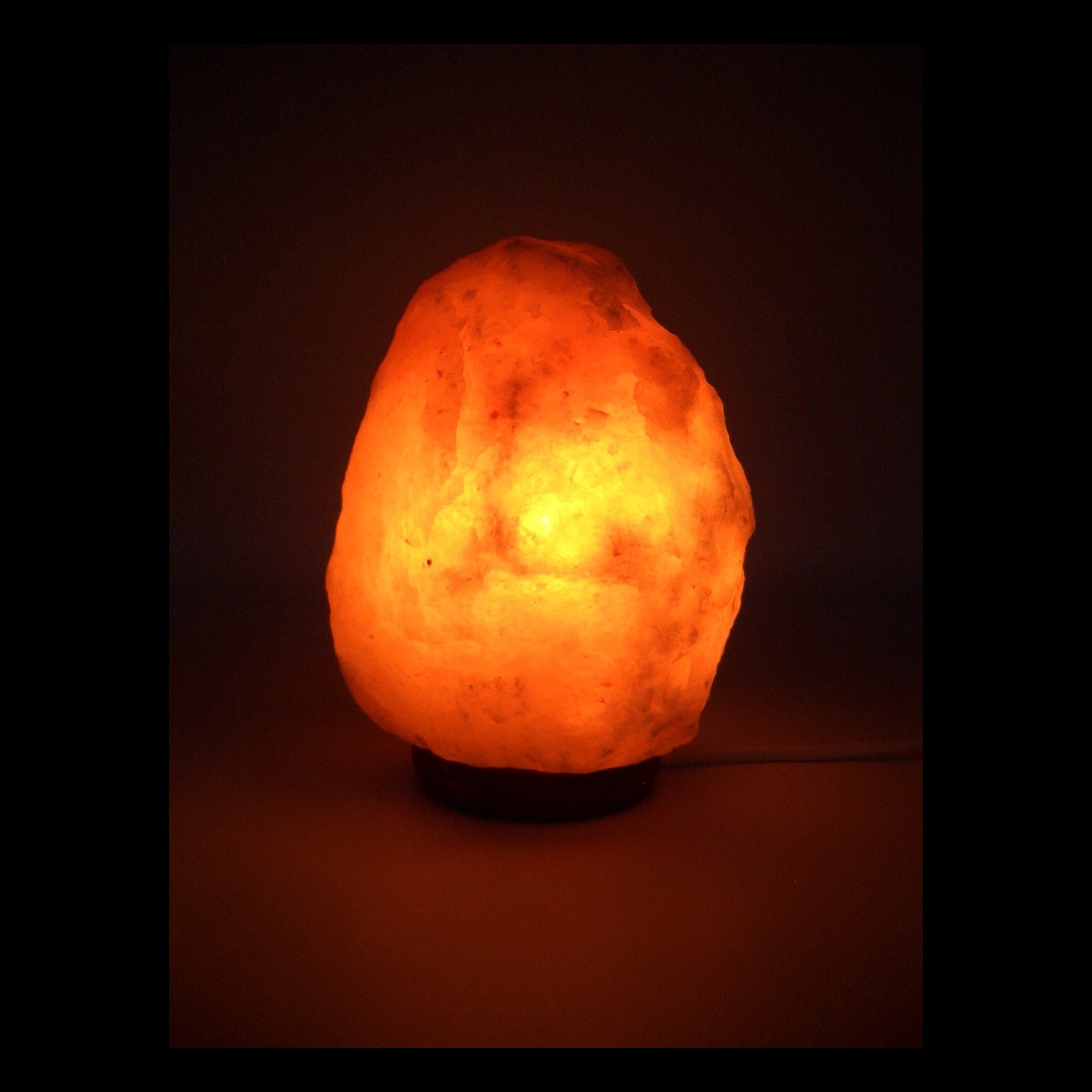 Mini lámpara de sal del Himalaya encendida sobre fondo oscuro